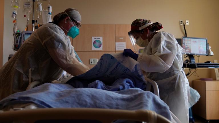 In this Dec. 22, 2020, file photo, registered nurses Robin Gooding, left, and Johanna Ortiz treat a COVID-19 patient at Providence Holy Cross Medical Center in the Mission Hills section of Los Angeles. (AP Photo / Jae C. Hong, File) In this Dec. 22, 2020, file photo, registered nurses Robin Gooding, left, and Johanna Ortiz treat a COVID-19 patient at Providence Holy Cross Medical Center in the Mission Hills section of Los Angeles. (AP Photo / Jae C. Hong, File)