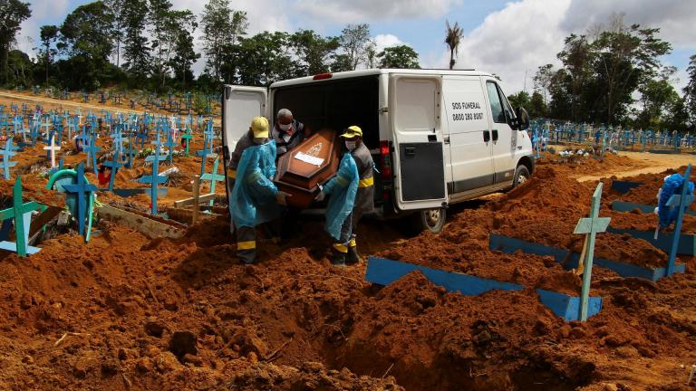 In this Jan. 6, 2021, file photo, cemetery workers carry the remains of 89-year-old Abilio Ribeiro, who died of the coronavirus, to bury at the Nossa Senhora Aparecida cemetery in Manaus, Amazonas state, Brazil. (AP Photo / Edmar Barros, File)