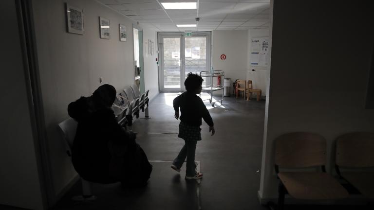 A child and his mother wait at the reception in the pediatric unit of the Robert Debre hospital, in Paris, France, Tuesday, March 2, 2021. (AP Photo/Christophe Ena)