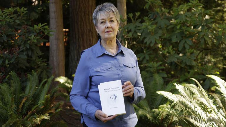 Karen McKnight stands in her backyard on Saturday, June 19, 2021, in Sammamish, Wash., holding two books written by her brother Ross Bagne of Cheyenne, Wyo. Nearly all COVID-19 deaths in the United States now are in people who weren’t vaccinated, like Bagne, a staggering demonstration of how effective the vaccines have been (AP Photo / John Froschauer)