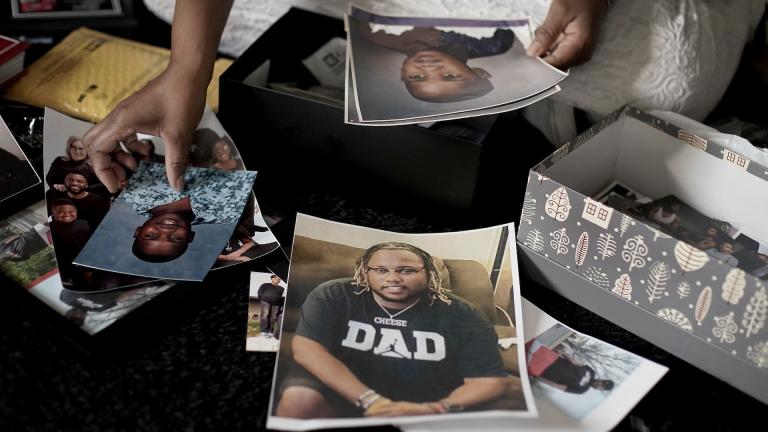 Carolyn Burnett sorts through mementos to select items to commemorate her son Chris Burnett on Sunday, Dec. 5, 2021, in Olathe, Kan. Chris Burnett, an unvaccinated 34-year-old father who coached football at Olathe East High School, died in September as a result of COVID-19 after nearly two weeks on a ventilator. ​ (AP Photo/Charlie Riedel)