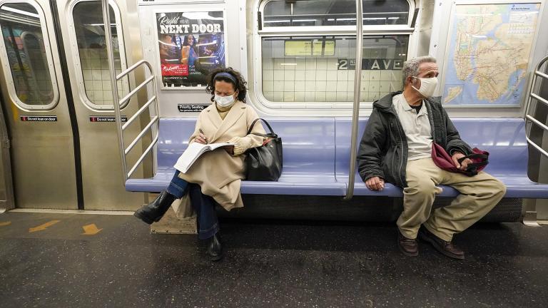 Commuters wear face masks and social distance while riding an M Train, Tuesday, March 9, 2021, in New York's subway system. (AP Photo / Mary Altaffer, File)