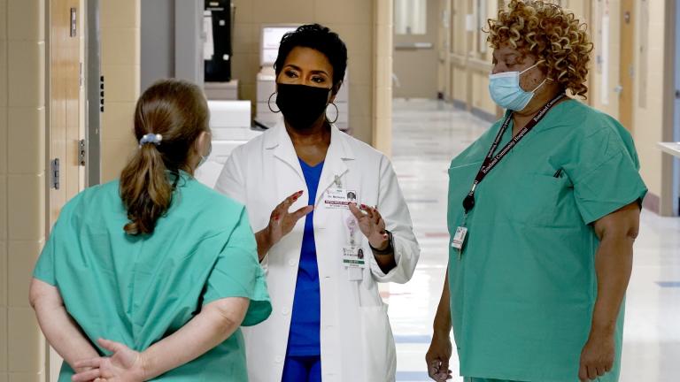 Dr. Rita McGuire, an obstetrician and infection control specialist at Roseland Community Hospital talks Friday, Jan. 29, 2021, with staff members about taking the COVID-19 vaccine. (AP Photo/Charles Rex Arbogast)