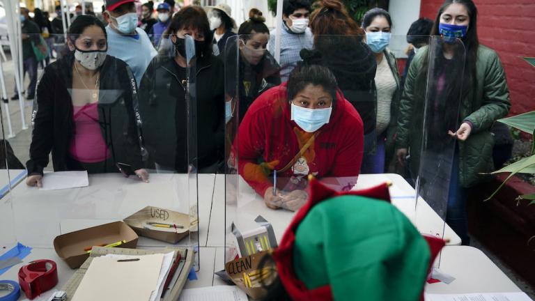 In this Dec. 17, 2020, file photo people check in at a food bank held at Los Angeles Boys & Girls Club in the Lincoln Heights neighborhood of Los Angeles. (AP Photo/Jae C. Hong,File)