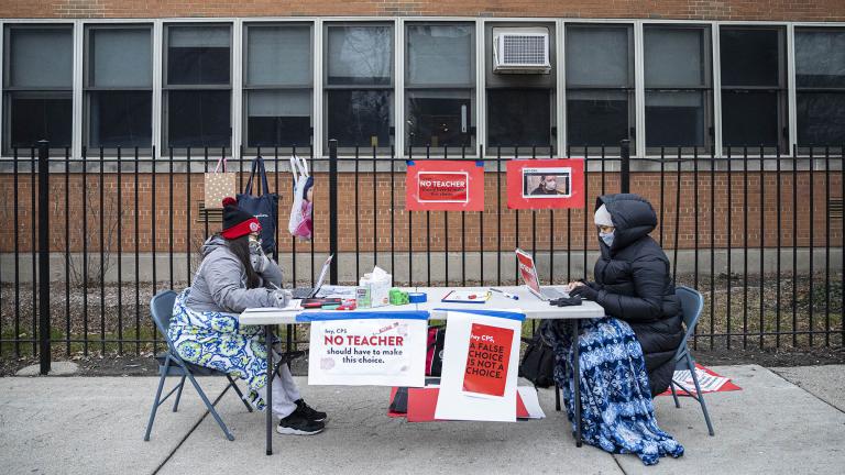 In this Monday, Jan. 11, 2021 file photo, teachers Adrienne Thomas, left, and Irene Barrera, right set up their computers and materials for their virtual classes outside of Suder Montessori Magnet Elementary School in solidarity with pre-K educators forced back into the building in Chicago. (Anthony Vazquez / Chicago Sun-Times via AP, File)