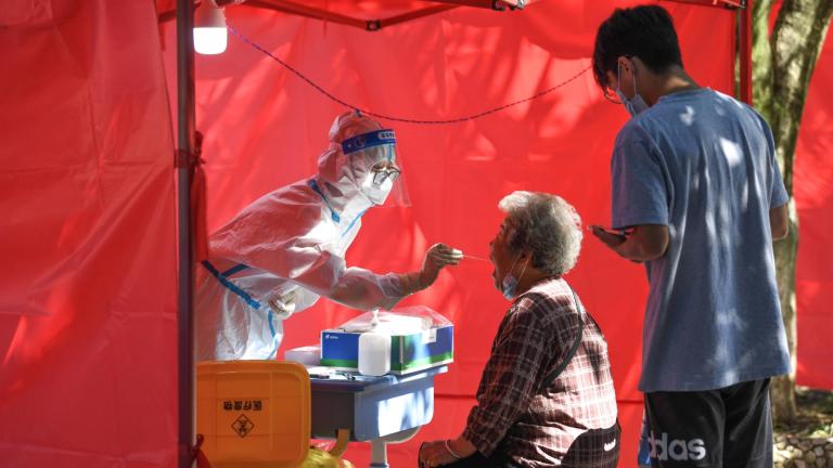 In this photo released by Xinhua News Agency, a medical worker takes a swab sample from a resident for nucleic acid test at a community testing site for COVID-19 in Yunyan District of Guiyang, Sept. 5, 2022. (Yang Wenbin / Xinhua via AP)