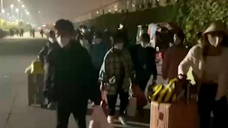 In this file photo taken from video footage and released by Hangpai Xingyang, people with suitcases and bags are seen leaving from a Foxconn compound in Zhengzhou in central China’s Henan Province on Oct. 29, 2022. (Hangpai Xingyang via AP, File)