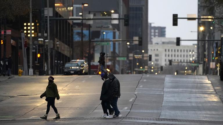 Pedestrians wear masks while crossing an empty road at the intersection of Market Street and 15th Avenue during the evening rush hour Monday, Dec. 28, 2020, in downtown Denver. (AP Photo / David Zalubowski) Pedestrians wear masks while crossing an empty road at the intersection of Market Street and 15th Avenue during the evening rush hour Monday, Dec. 28, 2020, in downtown Denver. (AP Photo / David Zalubowski)
