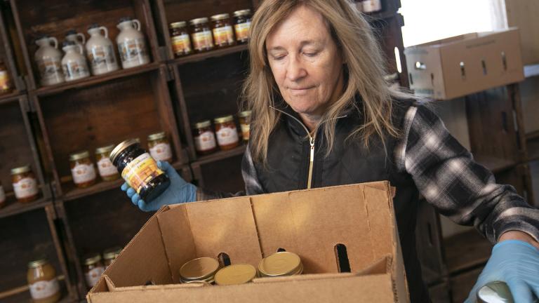 Linda DeFrancesco stocks shelves with her farm’s own salsa, spreads, veggies and salsa at DeFrancesco Farm Stand in Northford, Conn., Thursday, March 26, 2020. (Dave Zajac / Record-Journal via AP)