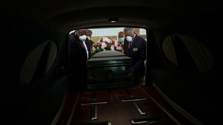 In this Saturday, April 18, 2020 file photo, mortician Cordarial O. Holloway, foreground left, funeral director Robert L. Albritten, foreground right, and funeral attendants Eddie Keith, background left, and Ronald Costello place a casket into a hearse in Dawson, Ga. (AP Photo / Brynn Anderson)