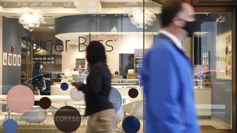 People walk past Sugar Bliss Bakery in Chicago’s famed Loop on Tuesday, May 4, 2021. (AP Photo / Shafkat Anowar)