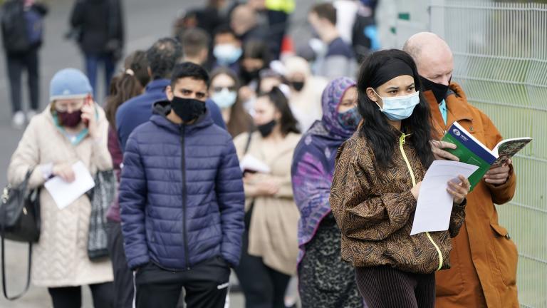 People queue to receive COVID-19 vaccinations at the ESSA academy in Bolton, England, Tuesday May 18, 2021. (Danny Lawson / PA via AP)