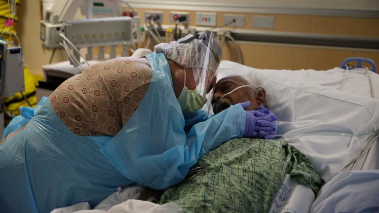 In this July 31, 2020, file photo, Romelia Navarro, 64, weeps while hugging her husband, Antonio, in his final moments in a COVID-19 unit at St. Jude Medical Center in Fullerton, Calif. (AP Photo / Jae C. Hong, File)