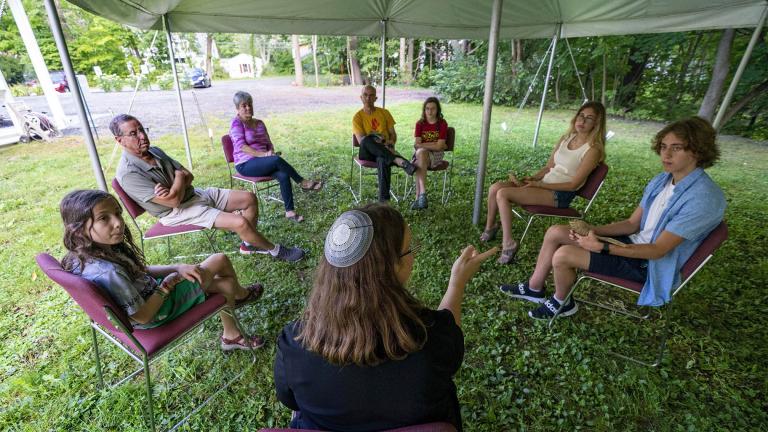 Rabbi Erica Asch, foreground center, teaches a class under a tent set upon outside Temple Beth El, Monday, Aug. 30, 2021, in Augusta, Maine. The recent COVID-19 upsurge has prompted the synagogue to erected a tent outside the temple to accommodate worshippers during the upcoming services. (AP Photo / Robert F. Bukaty)