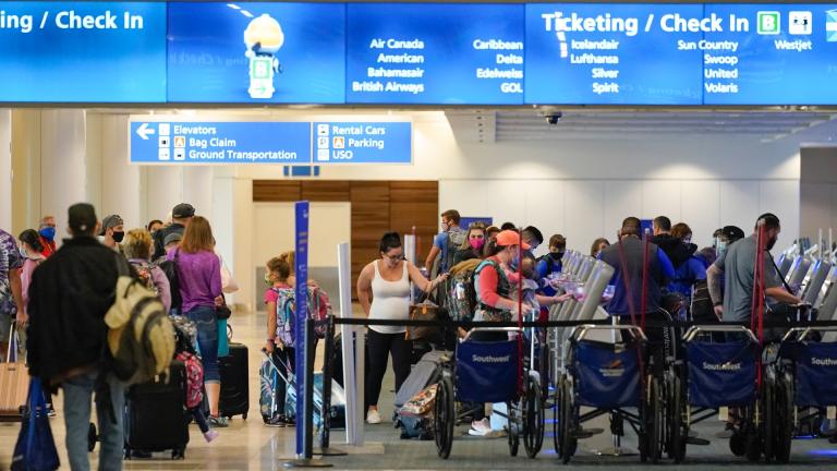 Holiday travelers check in at kiosks near an airline counter at Orlando International Airport Tuesday, Nov. 24, 2020, in Orlando, Fla. (AP Photo / John Raoux)