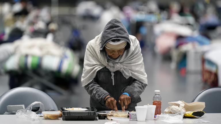 A woman eats at a homeless shelter inside the San Diego Convention Center Tuesday, Aug. 11, 2020, in San Diego. (AP Photo / Gregory Bull)