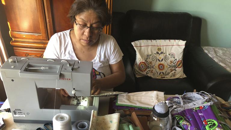In this April 7, 2020, photo provided by Maribel Torres, Maribel Torres sews face masks masks to be used for protection against the coronavirus at her home in the Staten Island borough of New York. (Pablo Evangelista / Torres Family Photo via AP) In this April 7, 2020, photo provided by Maribel Torres, Maribel Torres sews face masks masks to be used for protection against the coronavirus at her home in the Staten Island borough of New York. (Pablo Evangelista / Torres Family Photo via AP)