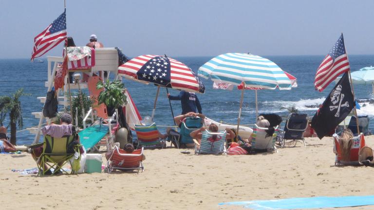 Flags line the beach in Belmar, N.J., on June 28, 2020. With large crowds expected at the Jersey Shore for the July Fourth weekend, some are worried that a failure to heed mask-wearing and social distancing protocols could accelerate the spread of the coronavirus. (AP Photo / Wayne Parry)