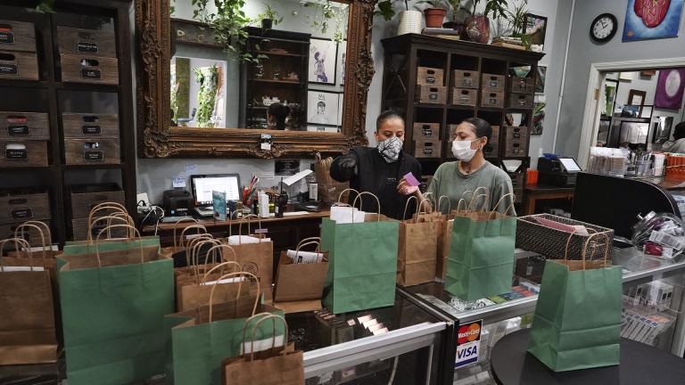 In this Thursday, April 16, 2020, photo, wearing a protective mask and gloves, budtenders prepare orders for customers to pick-up at The Higher Path cannabis dispensary in the Sherman Oaks section of Los Angeles. (AP Photo / Richard Vogel)