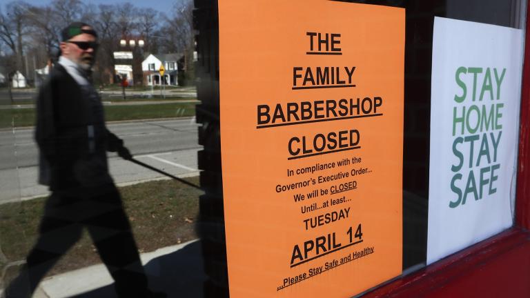 A pedestrian walks by The Family Barbershop, closed due to a Gov. Gretchen Whitmer executive order, in Grosse Pointe Woods, Mich., Thursday, April 2, 2020. (AP Photo / Paul Sancya)