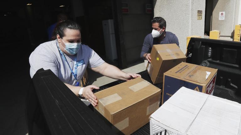 Christina Caldwell, left, of Henry Ford Population Health helps unload supplies with Matt Thatcher, who donated them from the Detroit Golf Club, Wednesday, April 8, 2020, in Detroit. (AP Photo / Carlos Osorio)