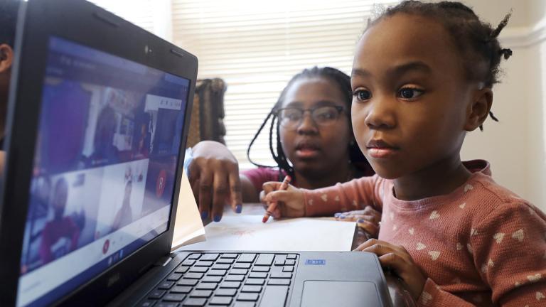 Lear Preston, 4, who attends Scott Joplin Elementary School, participates in her virtual classes as her mother, Brittany Preston, background, assists at their residence in Chicago's South Side, Feb. 10, 2021. (AP Photo / Shafkat Anowar, File)