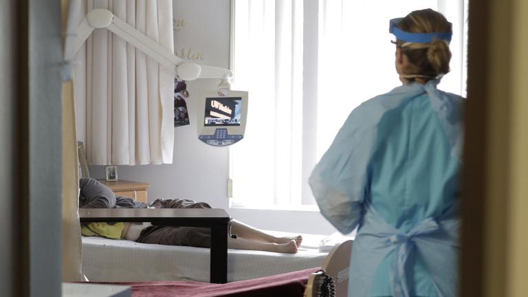 In this Friday, April 17, 2020 file photo, a health worker arrives to take a nose swab sample as part of testing for the COVID-19 coronavirus at a nursing and rehabilitation facility in Seattle. (AP Photo / Ted S. Warren)
