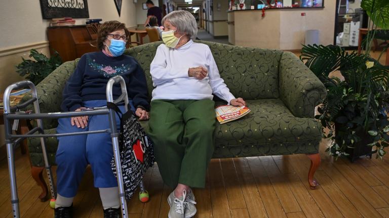 Carmela Sileo, left, and Susan McEachern sit next to each other and talk in the dayroom Wednesday, Feb. 3, 2021, at Arbor Springs Health and Rehabilitation Center in Opelika, Ala. (AP Photo / Julie Bennett)