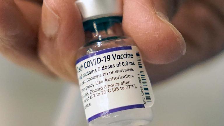 A doctor loads a dose of Pfizer COVID-19 vaccine into a syringe in a Dec. 2, 2021, file photo at a mobile vaccination clinic in Worcester, Mass. (AP Photo / Steven Senne, File)
