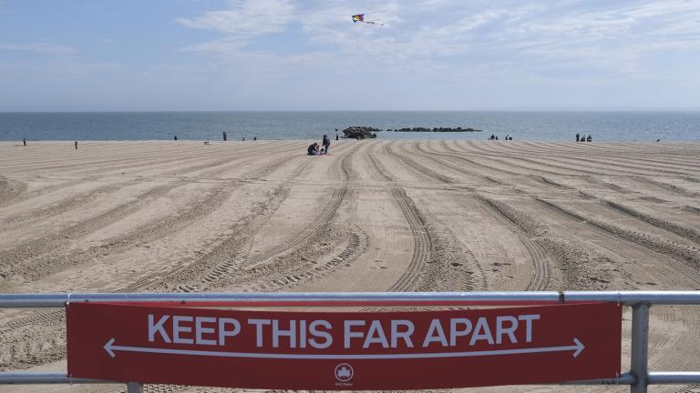 In this April 12, 2020, file photo, a sign on the Coney Island boardwalk reminds people to keep their distance in New York. (AP Photo / Seth Wenig, File)