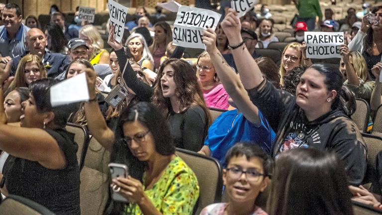 In this Aug. 25, 2021 file photo, people hold signs and chant during a meeting of the North Allegheny School District school board regarding the district's mask policy, at at North Allegheny Senior High School in McCandless, Pa. (Alexandra Wimley/Pittsburgh Post-Gazette via AP, File)