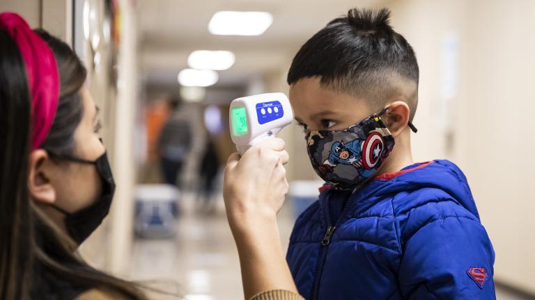 In this Jan. 11, 2021, file photo, a preschool student gets his temperature checked as he walks into Dawes Elementary School in Chicago. (Ashlee Rezin Garcia / Chicago Sun-Times via AP, Pool, File)