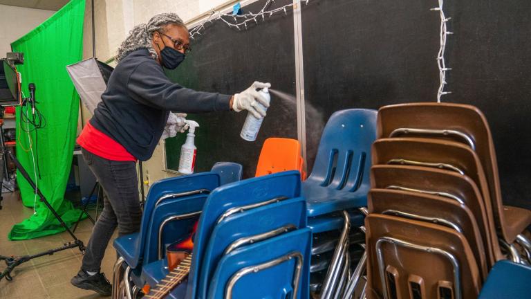 In this Thursday, March 4, 2021, file photo, Latisha Bledsoe cleans chairs in the music room at Manchester Academic Charter School during the coronavirus pandemic in Pittsburgh. The school is planning to return students to the classroom in a hybrid schedule at the end of March. (Andrew Rush / Pittsburgh Post-Gazette via AP, File)