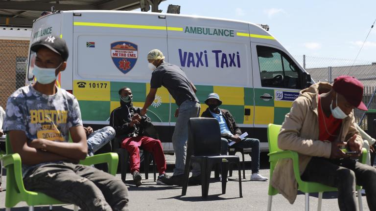 People wait to be vaccinated by a member of the Western Cape Metro EMS (Emergency Medical Services) at a mobile "Vaxi Taxi" which is an ambulance converted into a mobile COVID-19 vaccination site in Blackheath in Cape Town, South Africa, Tuesday, Dec. 14, 2021. (AP Photo/Nardus Engelbrecht)