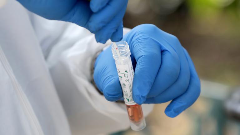 In this April 16, 2020, file photo, a medical worker places a swab in a vial while testing the homeless for COVID-19 through the Miami-Dade County Homeless Trust, during the new coronavirus pandemic, in Miami. (AP Photo / Lynne Sladky, File)