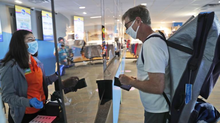 Amid concerns of the spread of COVID-19, a cashier and customer are separated by plexiglass at the city owned waterpark in Grand Prairie, Texas, Friday, May 29, 2020. Water parks in Texas were allowed to reopen today. (AP Photo/LM Otero) Amid concerns of the spread of COVID-19, a cashier and customer are separated by plexiglass at the city owned waterpark in Grand Prairie, Texas, Friday, May 29, 2020. Water parks in Texas were allowed to reopen today. (AP Photo/LM Otero)