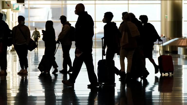 In this Nov. 25, 2020, file photo, air travelers line up to go through a a security checkpoint at Salt Lake City International Airport in Salt Lake City. (AP Photo / Rick Bowmer, File)