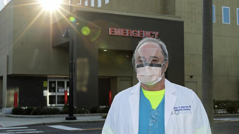 Dr. Stephen Anderson, a physician who works in the Emergency Department at the MultiCare Auburn Medical Center in Auburn, Wash., wears a mask and face shield as he poses for a photo before starting his shift, Tuesday, March 17, 2020, in Auburn, Wash., south of Seattle. (AP Photo / Ted S. Warren)