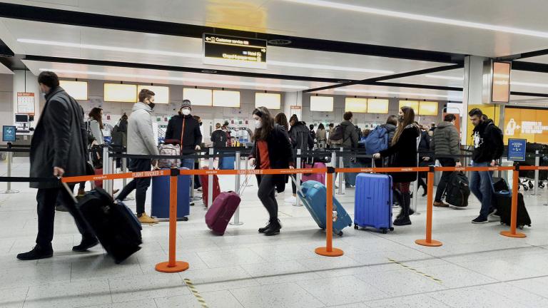 In this Dec. 20, 2020, file photo, passengers queue for check-in at Gatwick Airport in West Sussex, England, south of London. (Gareth Fuller / PA via AP) In this Dec. 20, 2020, file photo, passengers queue for check-in at Gatwick Airport in West Sussex, England, south of London. (Gareth Fuller / PA via AP)