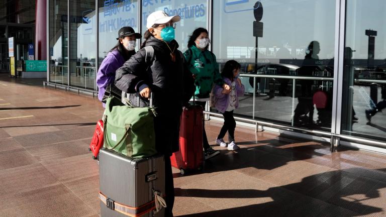 Passengers wearing masks walk through the Capital airport terminal in Beijing on Dec. 13, 2022. (AP Photo / Ng Han Guan, File)