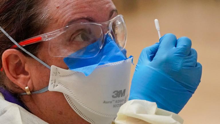 In this Nov. 11, 2020, file photo, Rachel Arden instructs a student on how to self-administer a rapid COVID-19 test at Weber State University in Ogden, Utah. (AP Photo / Rick Bowmer, File) In this Nov. 11, 2020, file photo, Rachel Arden instructs a student on how to self-administer a rapid COVID-19 test at Weber State University in Ogden, Utah. (AP Photo / Rick Bowmer, File)