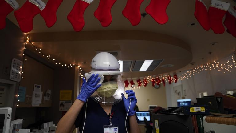 Registered nurse Romina Pacheco disinfects her powered air purifying respirator after tending to a patient in a COVID-19 unit decorated with Christmas stockings with nurses’ names written on them at Mission Hospital in Mission Viejo, Calif., Monday, Dec. 21, 2020. (AP Photo / Jae C. Hong)