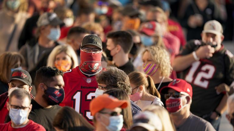 In this Feb. 4, 2021, file photo, people wait in line for an exhibit at the NFL Experience in Tampa, Fla. (AP Photo / Charlie Riedel, File)