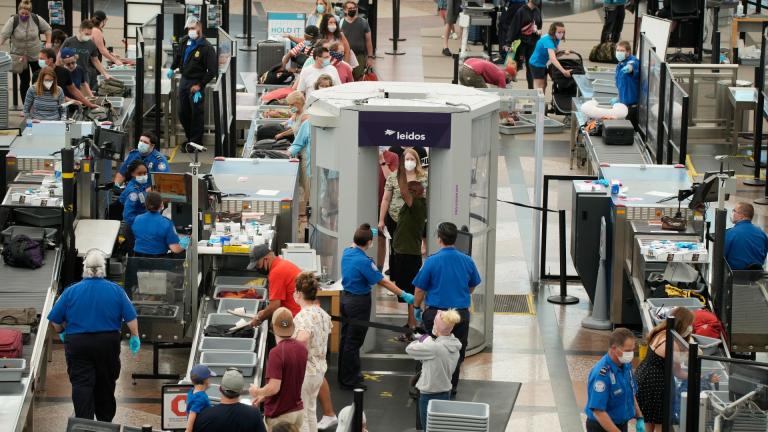 Travelers wear face coverings in the line for the south security checkpoint in the main terminal of Denver International Airport on Aug. 24, 2021, in Denver. (AP Photo / David Zalubowski)