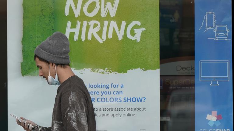 A man walks past a “Now Hiring” sign on a window at Sherwin Williams store, Friday, Feb. 26, 2021, in Woodmere Village, Ohio. (AP Photo / Tony Dejak)