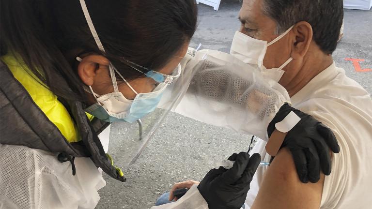 In this Feb. 8, 2021 file photo, Juan Delgado, 73, right, receives a COVID-19 vaccine shot from a health care worker at a vaccination site in the Mission district of San Francisco. (AP Photo / Haven Daley)