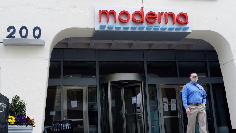 A man stands outside an entrance to a Moderna, Inc., building, Monday, May 18, 2020, in Cambridge, Mass. (AP Photo / Bill Sikes, file)