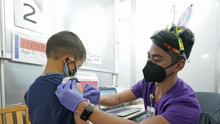 Andre Mattus, right, a nurse at the University of Washington Medical Center, gives the first shot of the Pfizer COVID-19 vaccine to Amar Gunderson, 6 1/2, Tuesday, Nov. 9, 2021, in Seattle. (AP Photo / Ted S. Warren)
