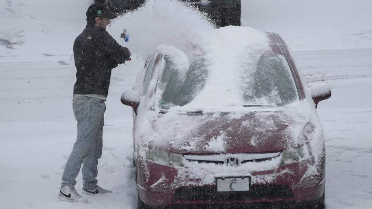 A person dusts snow off of a car during a winter storm, Sunday, Jan. 5, 2025, in Cincinnati. (AP Photo / Joshua A. Bickel)