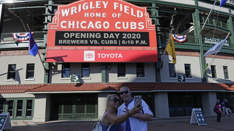 Sandra Bilger, left, and Dustin Moore take a photo in front of the marquee at Wrigley Field before an opening day baseball game between the Chicago Cubs and the Milwaukee Brewers in Chicago, Friday, July 24, 2020, in Chicago. (AP Photo / Nam Y. Huh)